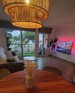 a dining room with a table and a large chandelier at SeaHomes Vacations - Seafront Mediterranean Ap & PKG in Blanes