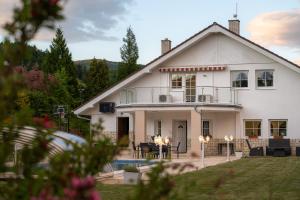 The Teplice Aqua Villa by Aura Luxury Collection في تبليتسه: بيت ابيض مع بلكونه وساحه