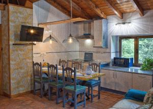 a dining room with a table and chairs in a kitchen at Las Casucas del Cartero in Cantabria