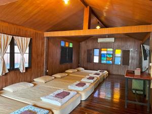 a room with four beds in it with wooden walls at Phuiyara Resort in Nakhon Nayok