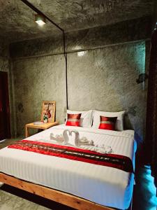 a bedroom with a large bed with red and white pillows at คีรีเขาสกริเวอร์ in Khao Sok
