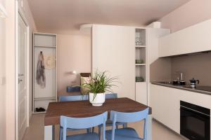 a kitchen with a wooden table and blue chairs at Freshwater Pirates SUITES in Gaeta