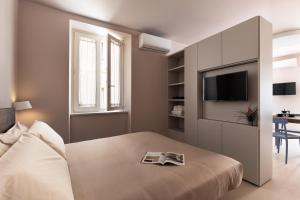 a bedroom with a bed with a tv on a wall at Freshwater Pirates SUITES in Gaeta