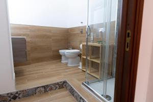 a bathroom with a toilet and a glass shower at La casa di PippiGiu in Marsala