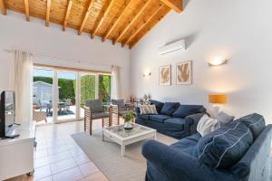 ein Wohnzimmer mit blauen Sofas und einem Fernseher in der Unterkunft Pita's House - Villa Sagres 2 in Sagres