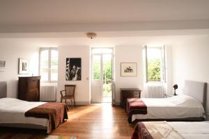 a bedroom with two beds and two windows at Domaine Argia in Sames +16 photos