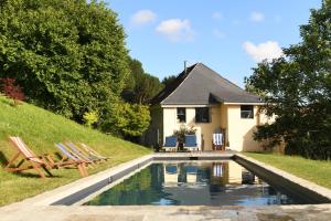 a house with a swimming pool in front of a house at Domaine Argia in Sames
