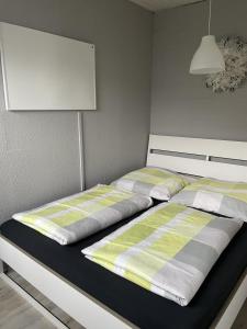 a bedroom with a bed with a yellow and gray comforter at Friesische Freiheit in Butjadingen OT Tossens