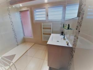 a white bathroom with a sink and a window at Appartement lumineux à 5 min des plages et commerces avec balcon, barbecue et parking inclus - FR-1-239-608 in Capbreton