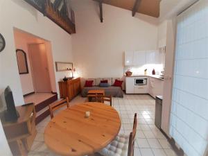 a living room with a wooden table and a kitchen at Appartement lumineux à 5 min des plages et commerces avec balcon, barbecue et parking inclus - FR-1-239-608 in Capbreton +20 photos