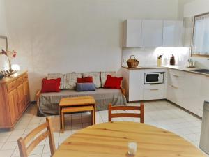 a kitchen and a living room with a couch and a table at Appartement lumineux à 5 min des plages et commerces avec balcon, barbecue et parking inclus - FR-1-239-608 in Capbreton
