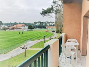 a balcony with a view of a baseball field at Appartement lumineux à 5 min des plages et commerces avec balcon, barbecue et parking inclus - FR-1-239-608 in Capbreton