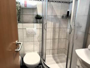 a bathroom with a shower with a toilet and a sink at Im Aida Park im Nordseebad Tossens liegt dieses geräumige Ferienhaus im mediterranen Stil. in Butjadingen OT Tossens +36 photos