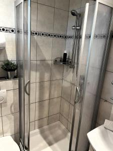 a shower with a glass door in a bathroom at Im Aida Park im Nordseebad Tossens liegt dieses geräumige Ferienhaus im mediterranen Stil. in Butjadingen OT Tossens