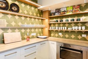 a kitchen with white cabinets and green wallpaper at Villa Delle Vigne in San Venanzo