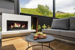 a living room with a fireplace and a couch at Cottonwood Villa in Arrowtown