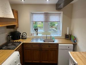 a kitchen with a sink and a window at 3 Bedroom Dog Friendly Cottage with Off Lead Field in Airton