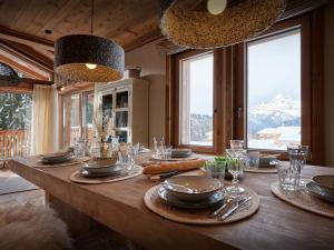 Un comedor con una mesa con platos y vasos. en Chalet Marmot'Inn - OVO Network, en Notre-Dame-de-Bellecombe 20 fotos más