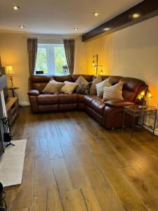 a brown leather couch in a living room at 3 Bedroom Dog Friendly Cottage with Off Lead Field in Airton