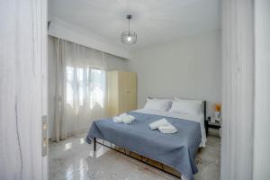 a white bedroom with a bed with towels on it at House 2BD Private Parking Next to Center in Asprovalta
