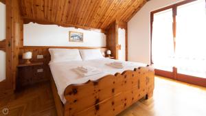 a bedroom with a large bed with a wooden ceiling at Italianway - Besta 2 in Bormio