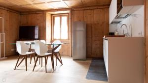 Una cocina con mesa y sillas y un refrigerador. en Italianway - Dei Sana 8 Yellow Submarine, en Valdidentro 15 fotos más