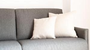 a gray couch with a white pillow on it at Italianway - Al Forte 6 in Valdisotto