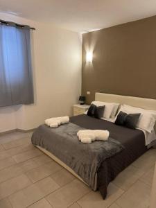 una camera da letto con un letto grande con due asciugamani sopra di Domu Grìsia Apartment Arzachena a Arzachena