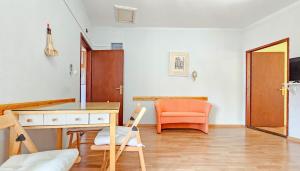 ノヴィグラード・イストラにあるMargarita 2の机とオレンジ色の椅子のある部屋