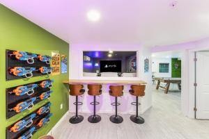 a room with a bar with stools and a tv at Stay And Play 18 Guest Family Fun - Pickleball Court in Sevierville