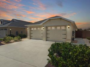 a large house with a garage with a driveway at Charming Courtyard Villa In The Villages in Wildwood