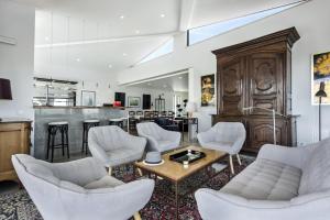 a living room with white furniture and a bar at La Glycine in Castro Marim