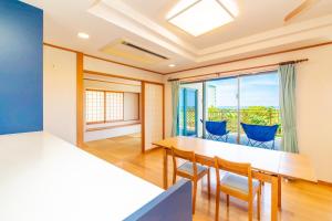 ein Esszimmer mit Tisch und Stühlen und einem Fenster in der Unterkunft max 8 people, 2LDK -Sion-Maezato in Ishigaki-jima