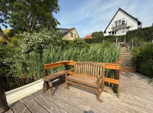 Eine Holzbank steht auf einer Holzterrasse. in der Unterkunft Lakeside Plön in Plön