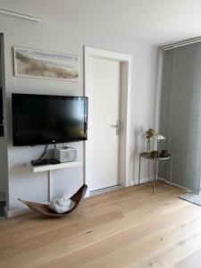ein Wohnzimmer mit einem Flachbildfernseher an der Wand in der Unterkunft Lakeside Plön in Plön