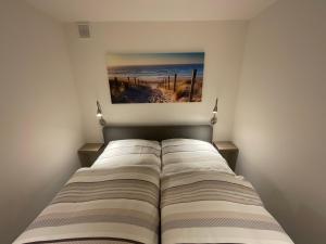 ein Bett in einem Zimmer mit einem Bild an der Wand in der Unterkunft Lakeside Plön in Plön