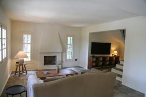a living room with a couch and a tv at Villa Rhodos Skiathos in Skiathos