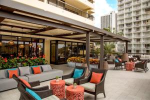 a patio with couches and tables and chairs at Luxury Oceanfront High Floor at Waikiki Beach Tower in Honolulu