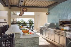 a kitchen with a counter and a table with food at Luxury Oceanfront High Floor at Waikiki Beach Tower in Honolulu