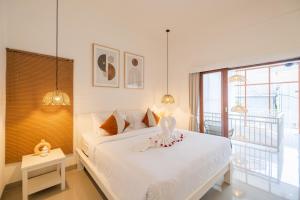 une chambre avec un lit blanc et une grande fenêtre dans l'établissement Villa OG Cruz and OG Cove - Central & Modern Canggu Pool Villas - Sleeps 14, à Canggu 75 autres photos
