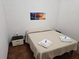 a bedroom with a bed with two towels on it at La casa di PippiGiu in Marsala +6 photos