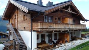 a large wooden house with a balcony on top at Skihütte Silberleiten, 14 Personen in Krimml