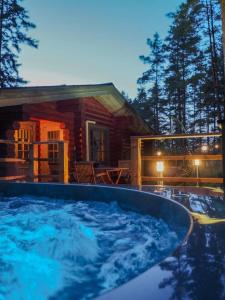einem großen Whirlpool vor einem Blockhaus in der Unterkunft Villa Pihlajanmarja is a Stunning Log Villa on a Waterfront Estate in Långstrand