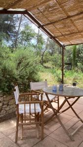 a picnic table and two chairs under a pavilion at Le havre de paix Gîte insolite avec spa sous les étoiles in Mirabel-aux-Baronnies