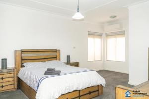 a bedroom with a large bed and two windows at Luxury Desert Paradise in Kalgoorlie +7 photos