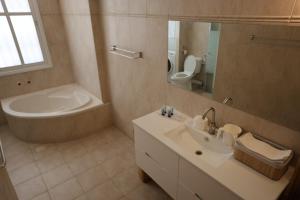 a bathroom with a tub and a sink and a mirror at Vacation rental in Netanya