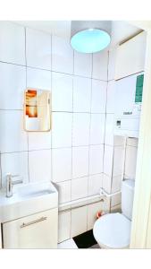 a white bathroom with a toilet and a sink at Charming 3-bedroom House with Garden in Portsmouth, Close Parking, Train Station & Gunwharf in Portsmouth +18 photos
