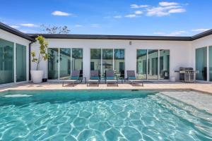 a swimming pool in a house with glass windows at Equestrian Stay, Heated Pool, Game Room, Fire Pit in Loxahatchee