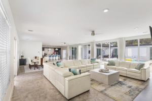 a living room with white couches and a table at Equestrian Stay, Heated Pool, Game Room, Fire Pit in Loxahatchee