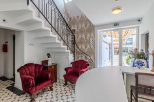 a living room with two red chairs and a staircase at Fulop Panzio Rooms in Révfülöp +68 photos